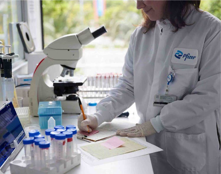 A lab technician making notes