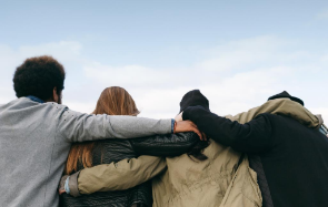 Four friends with arms around each other