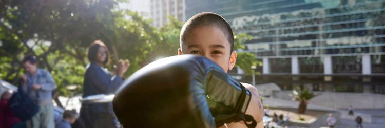 A young, gloved boxer punching forward