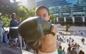 A young, gloved boxer punching forward