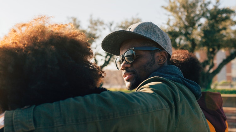 A black man with an arm around a black woman