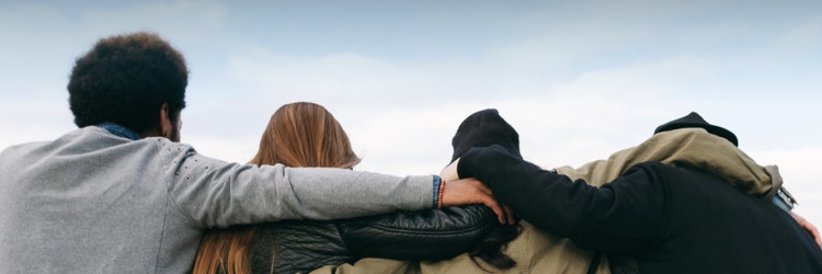 Four friends with arms around each other