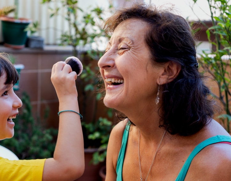 Smiling woman playing with a child