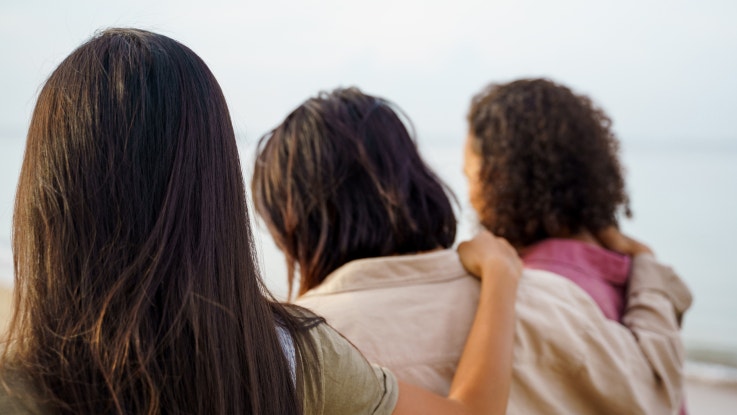 Three women with their arms around each other