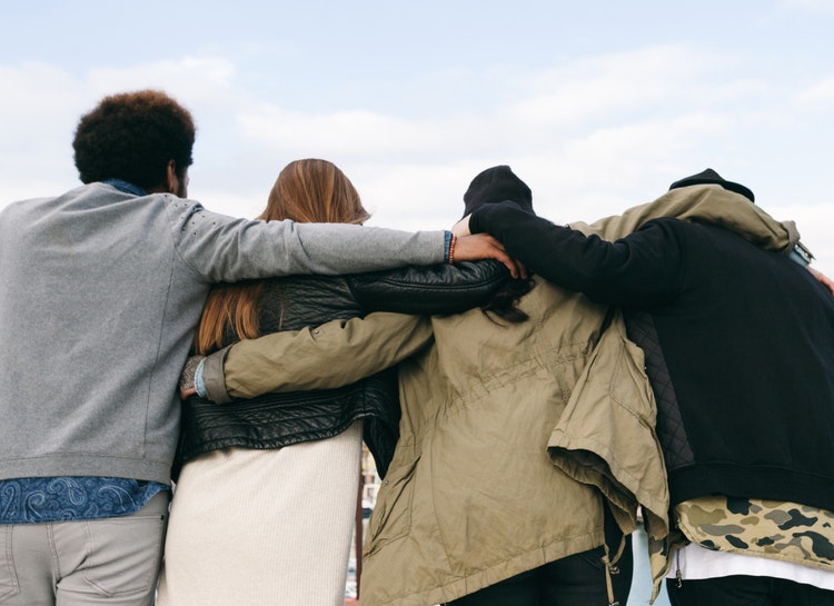 Four friends with arms around each other