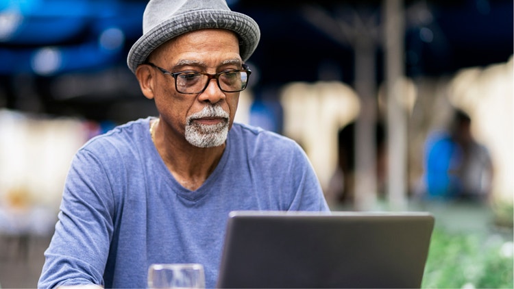 An older black man looking at a computer