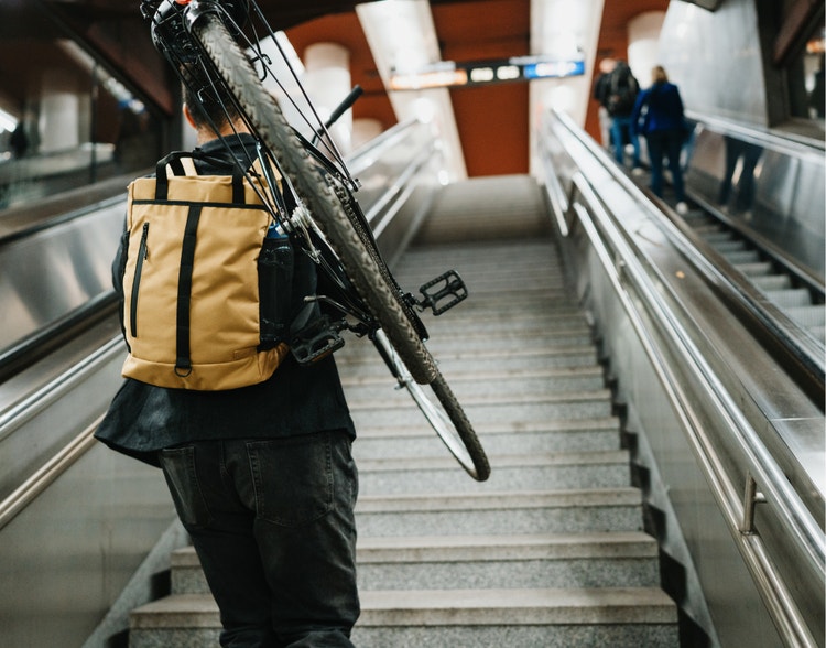 A person carrying a bike upstairs