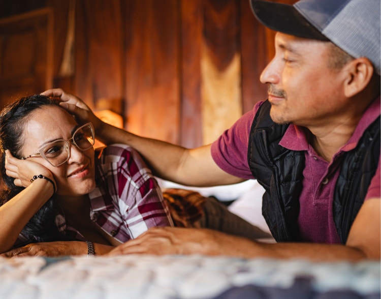 A man and a woman looking at each other on a bed